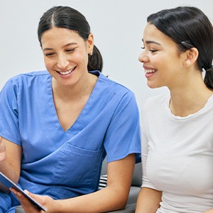 A woman discussing dental insurance with her dentist