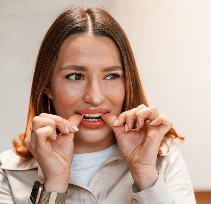 Patient putting on clear aligner in treatment room
