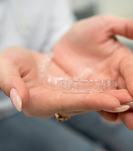 Closeup of patient holding clear aligner
