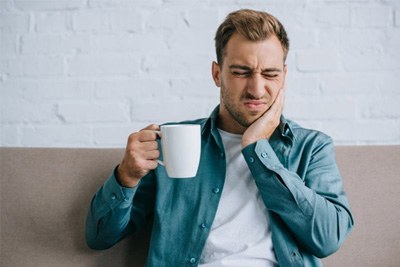 Patient in Blue Springs holding cheek at dentist