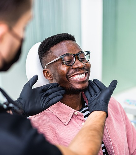 Dentist looking at smiling patient's teeth