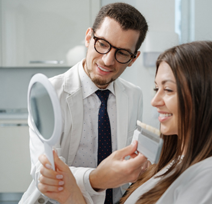 A dentist showing veneers to his patient