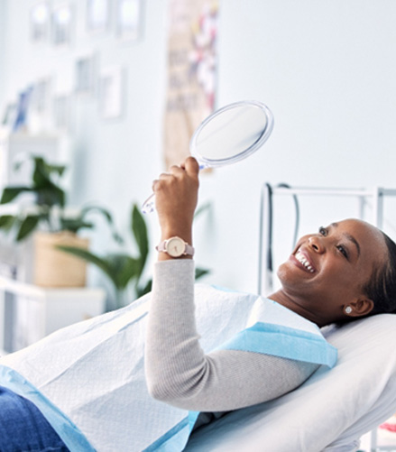 Woman smiling while looking at reflection in mirror