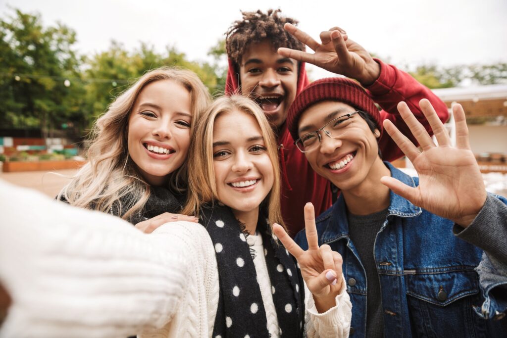 Four smiling teens taking selfie together